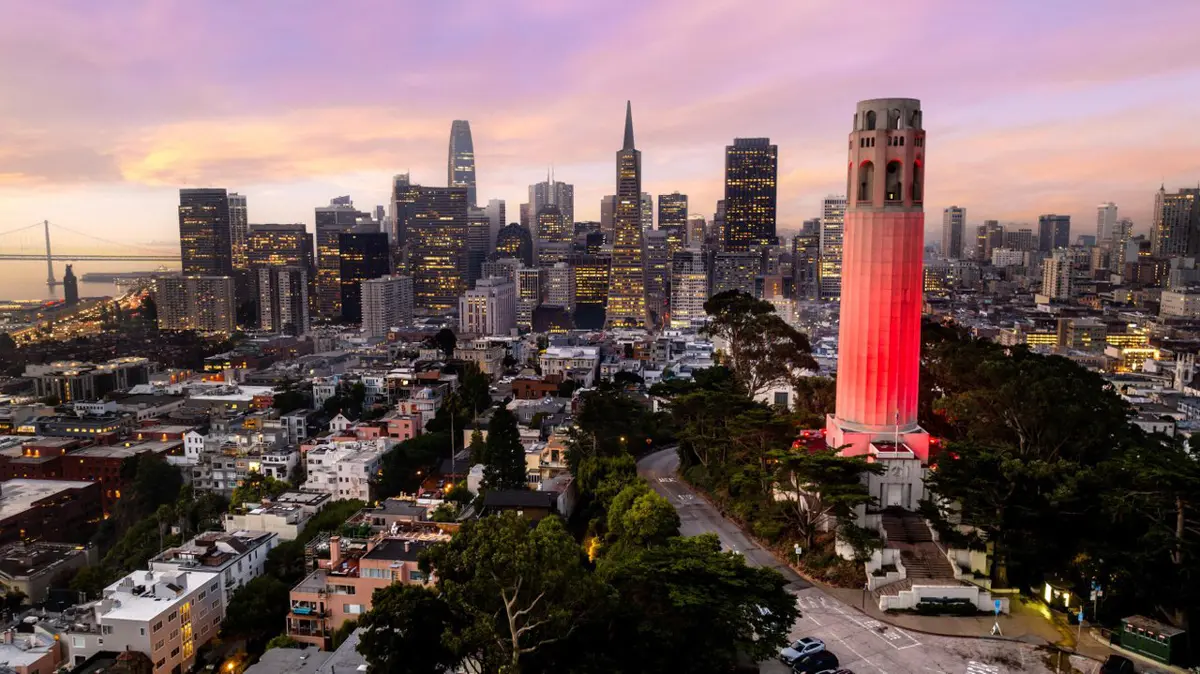 Coit Tower lit up in front of the the San Francisco skyline