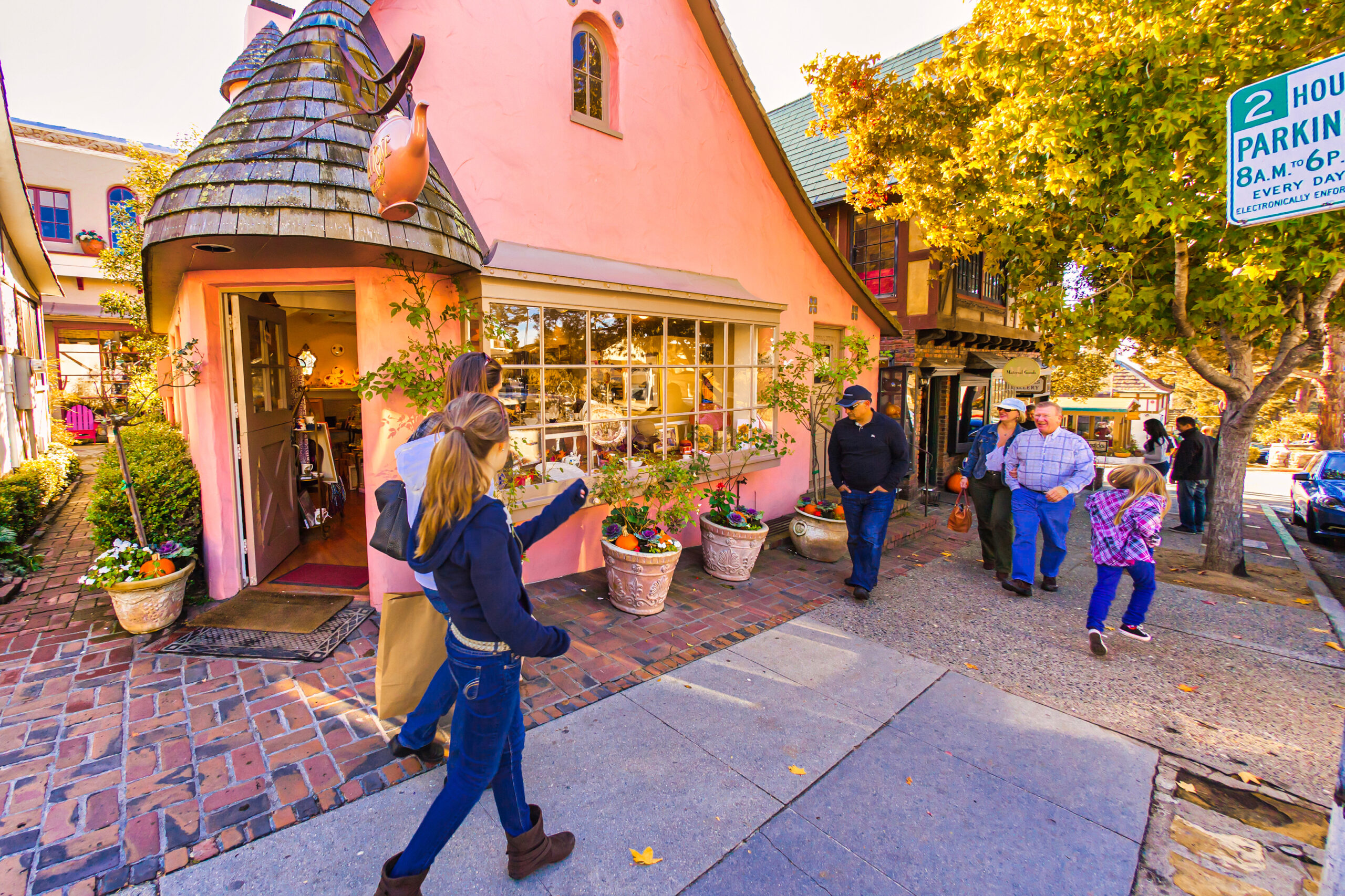 Busy shopping street in Carmel-by-the-Sea with storybook looking cottage and shops