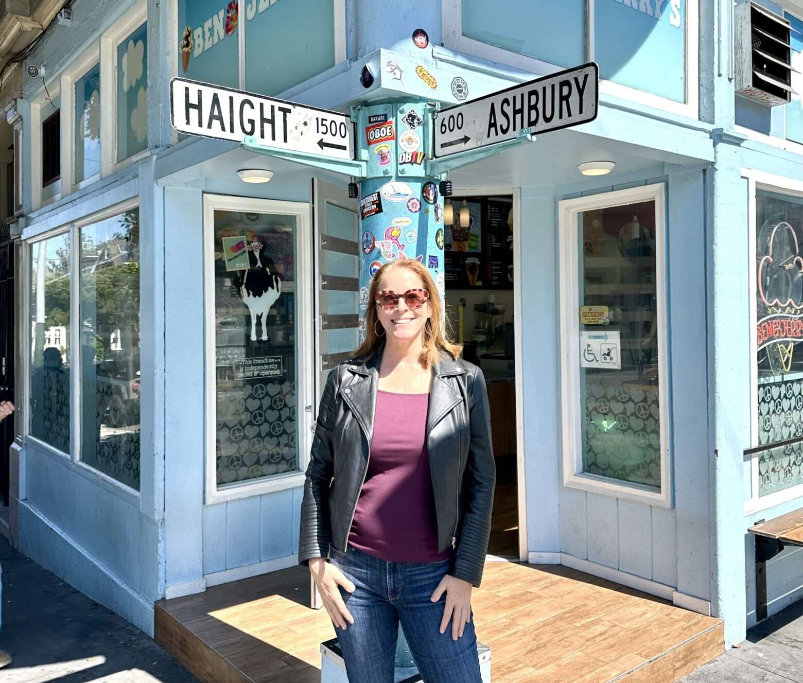 Standing under the signs at the corner of Haight and Ashbury street in San Francisco