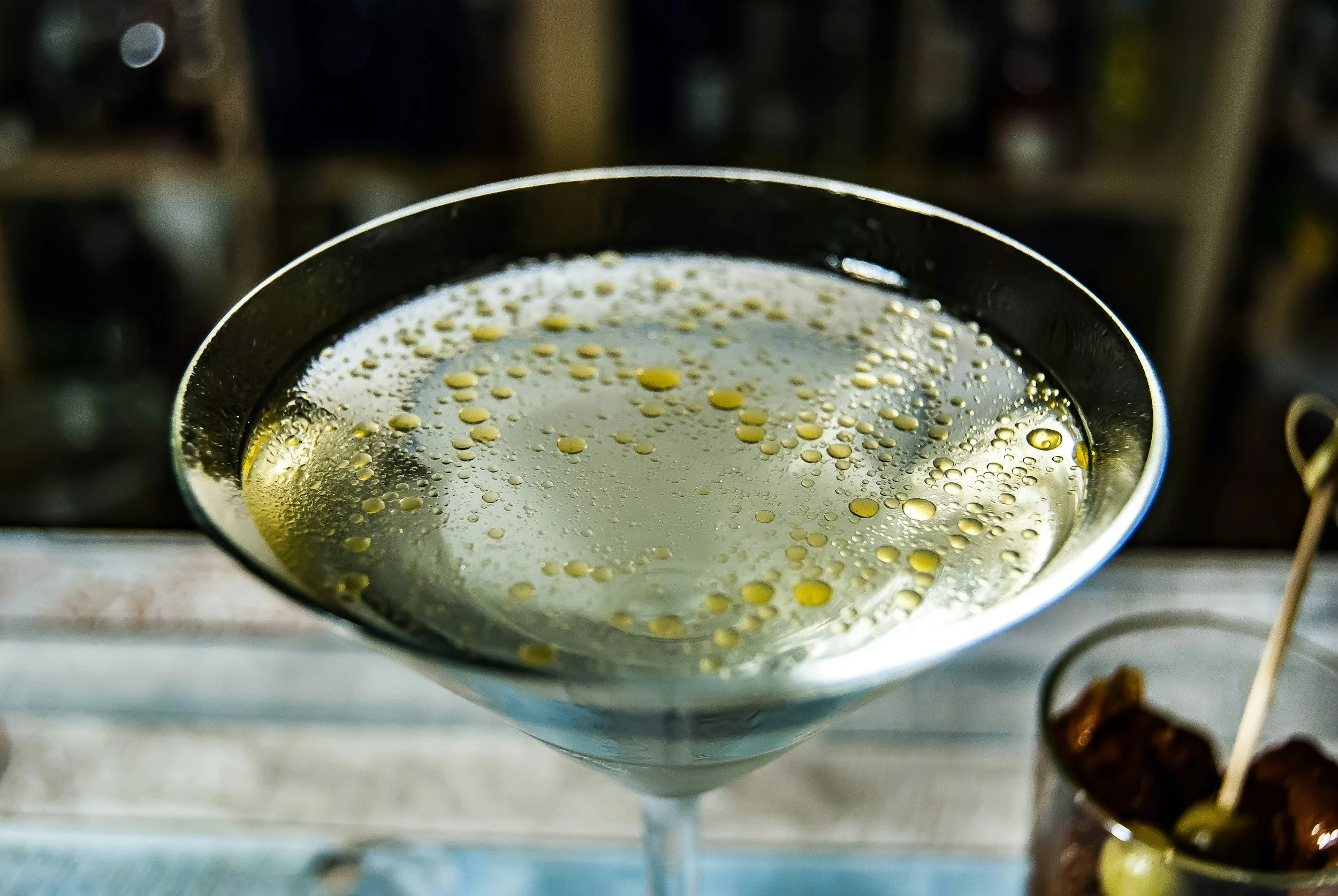 Martini in a glass with splash of olive oil