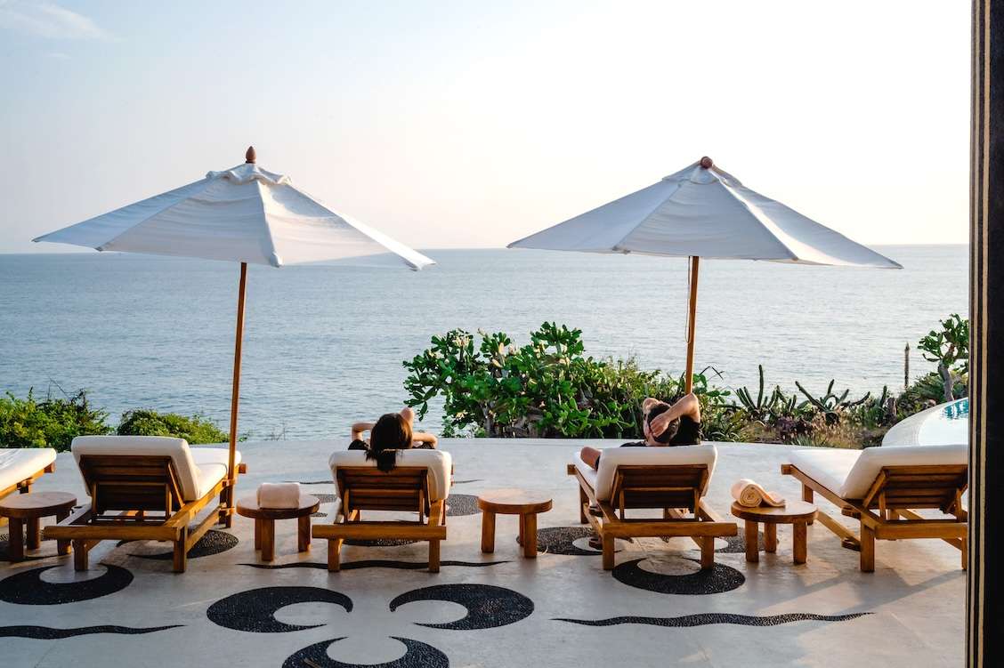 couple lounging by the pool and ocean in Careyes, mexico