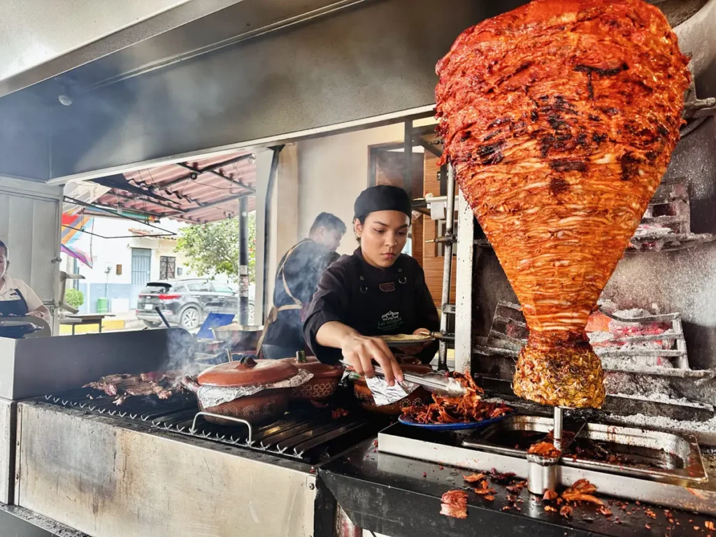 woman in puerto vallarta carving al pastor for tacos