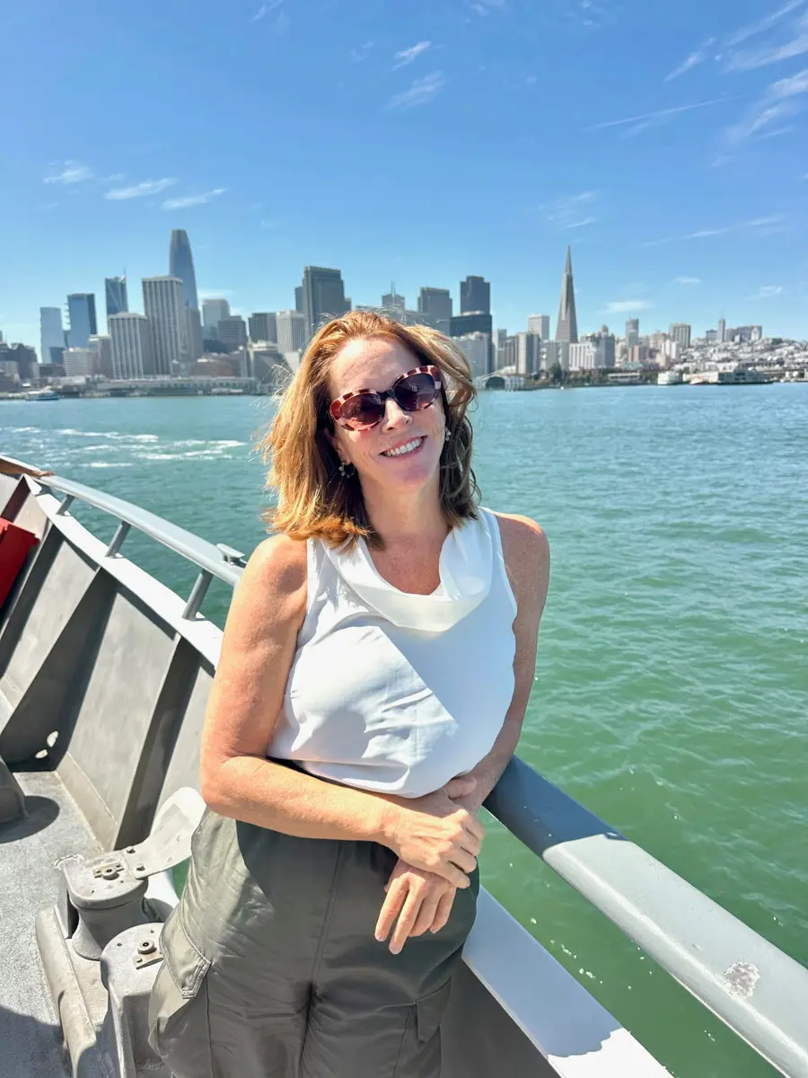 woman riding the ferry to san francisco with the city skyline in the background