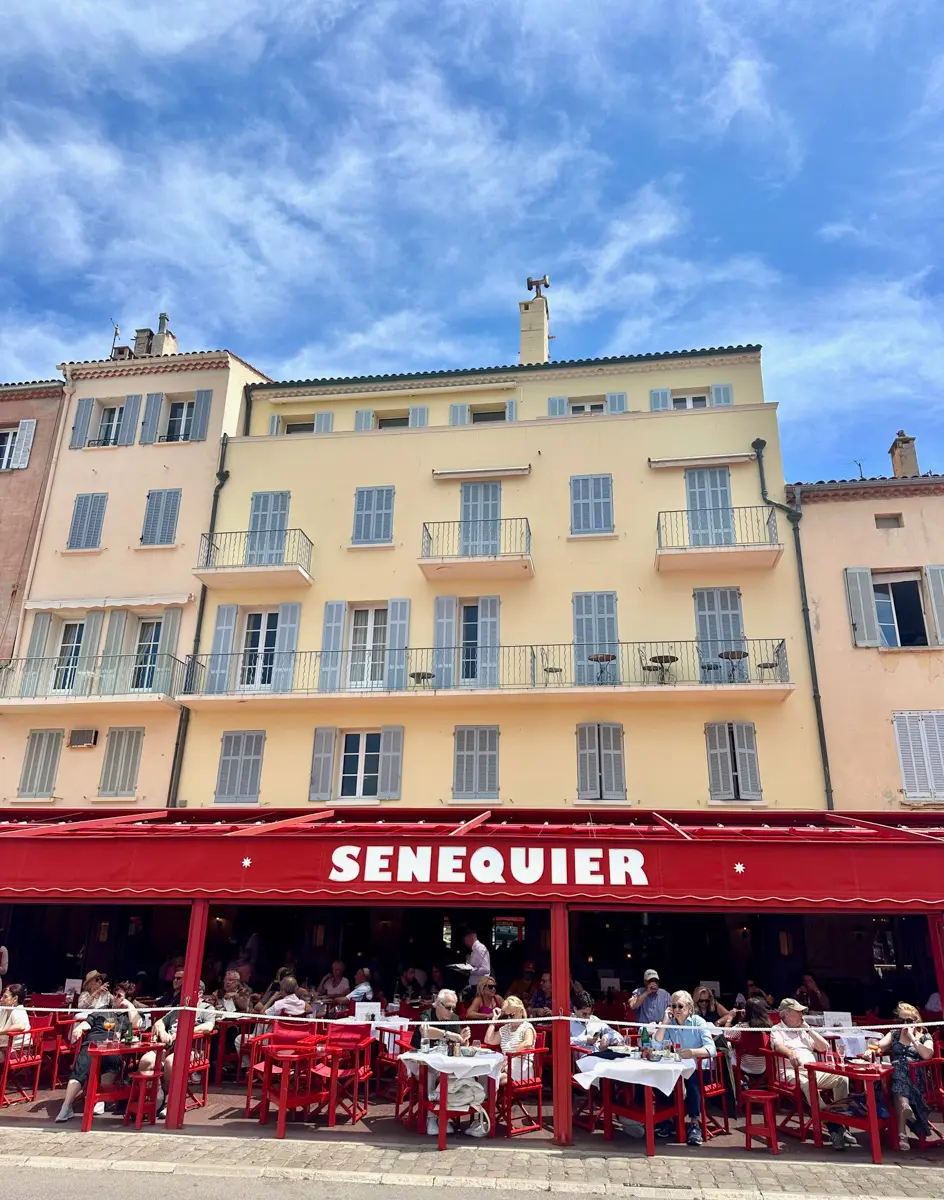 senequier cafe in saint tropez with red awning and people at tables