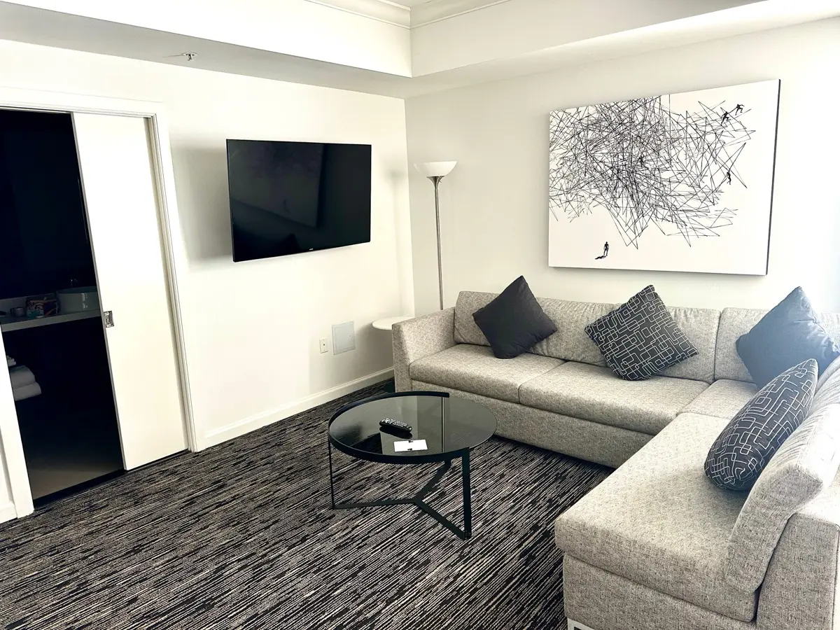 hotel zelos suite living room with l-shaped sofa and tv