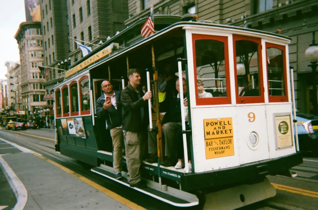 two men riding a cable car in union square in san francisco