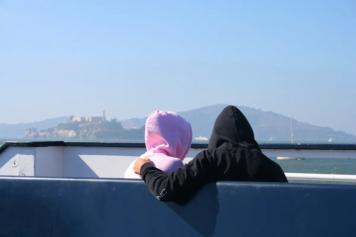 couple dressed in hoodies on a boat in san francisco