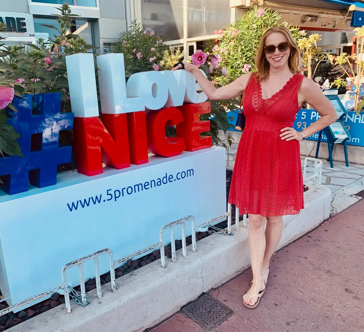woman standing near I love Nice sign in France