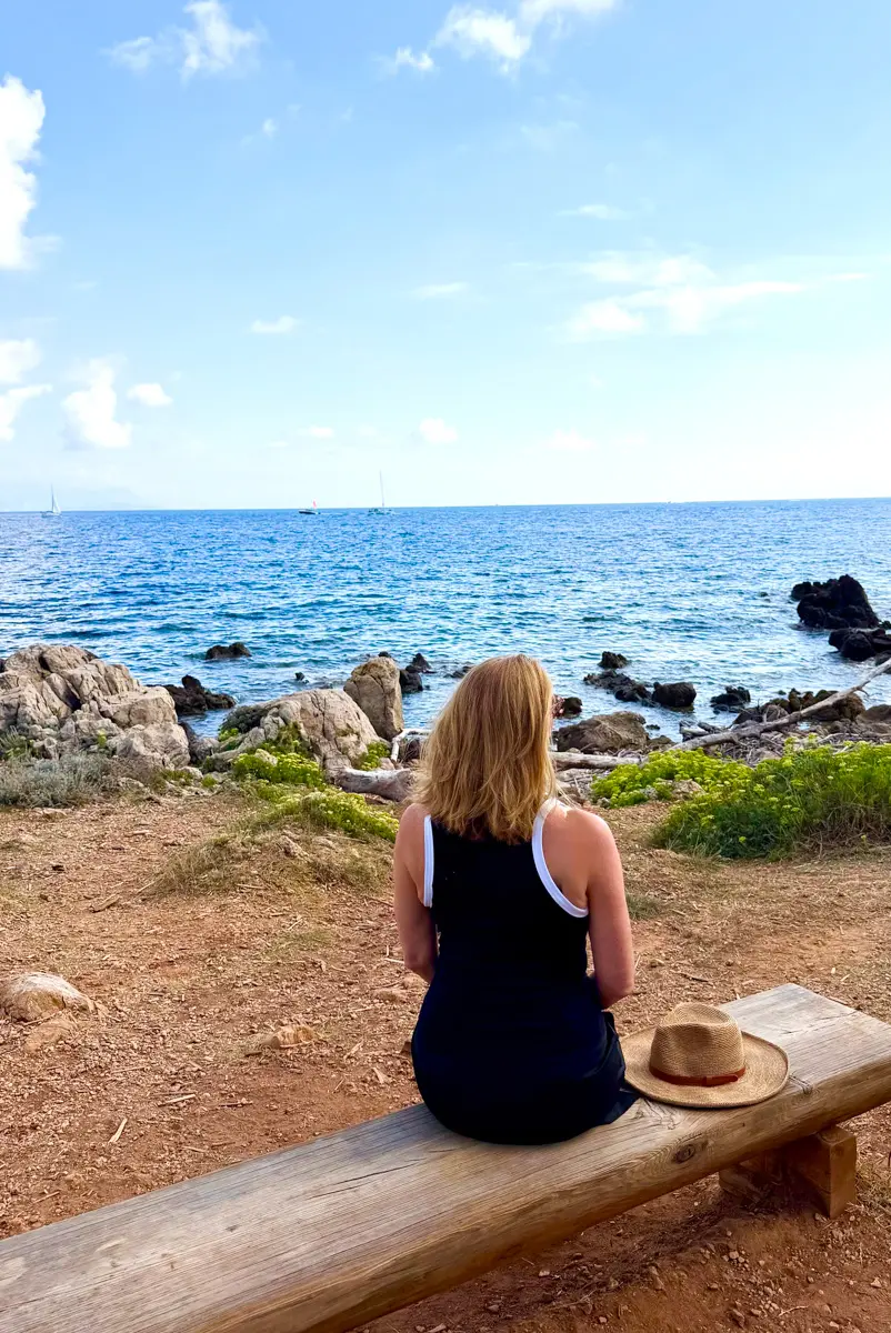 woman on bench in antibes on tire-poil walking trail
