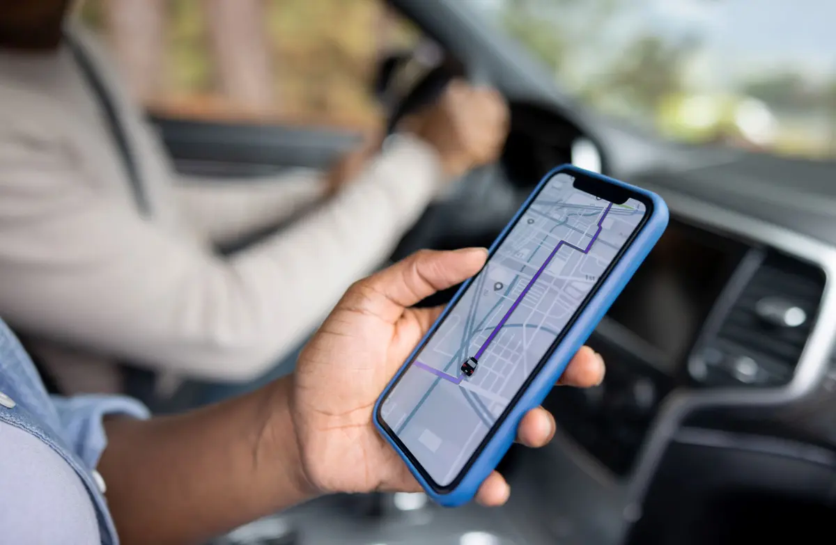 passenger in car using phone transportation app
