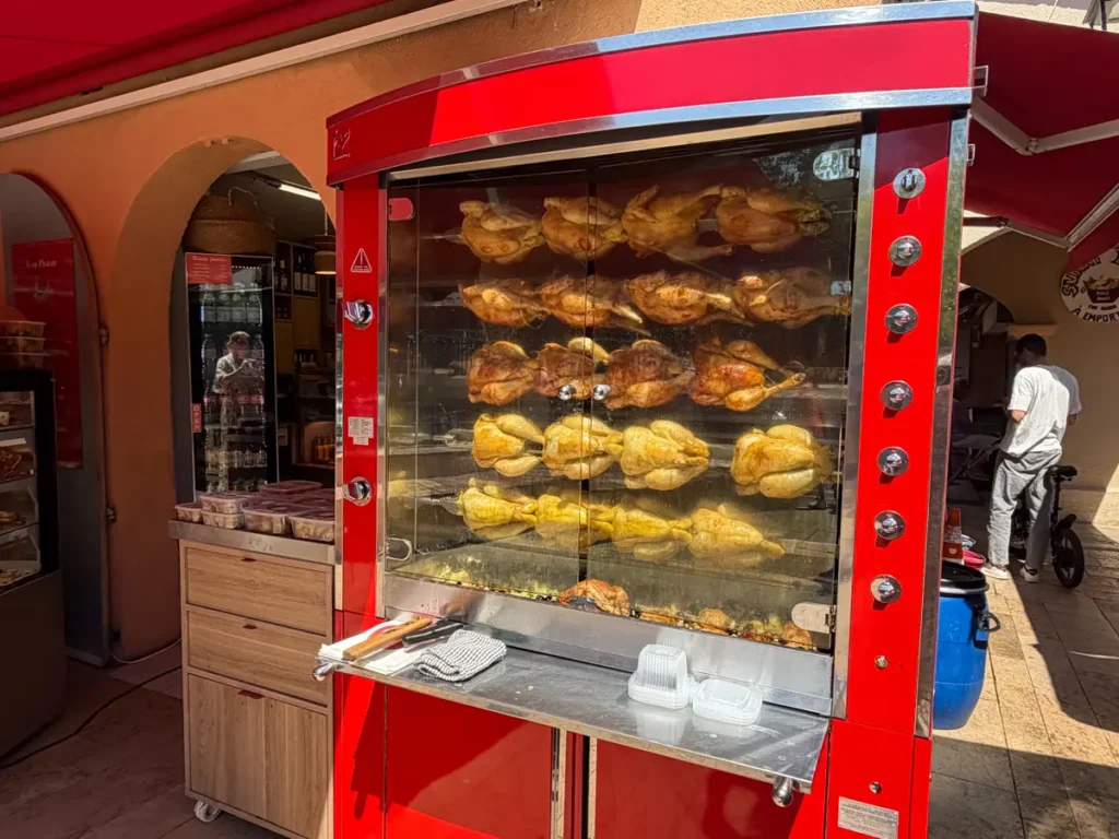 rotisserie chickens roasting at a local market