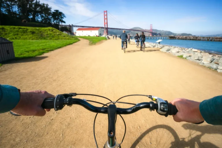 biker on crissy field in san francisco with golden gate bridge in background