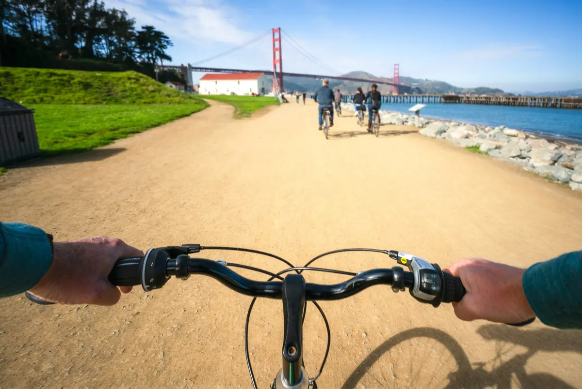 biker on crissy field in san francisco with golden gate bridge in background