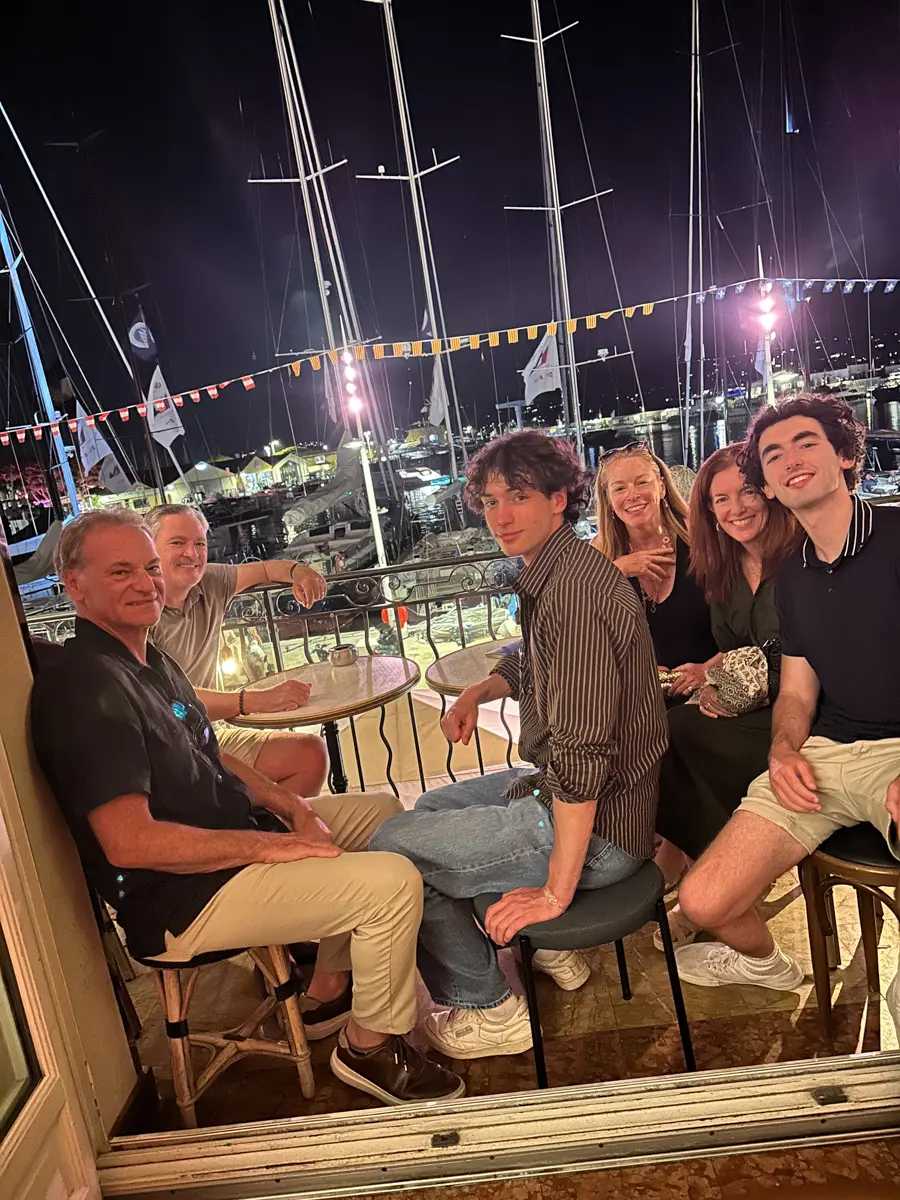 people on the balcony of le sube in saint tropez at night looking at boats in port