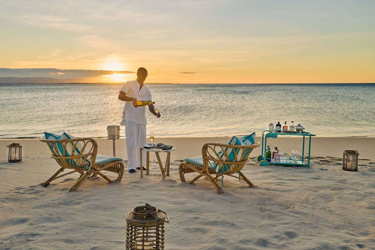 seaside happy hour at miavana with champagne poured at sunset