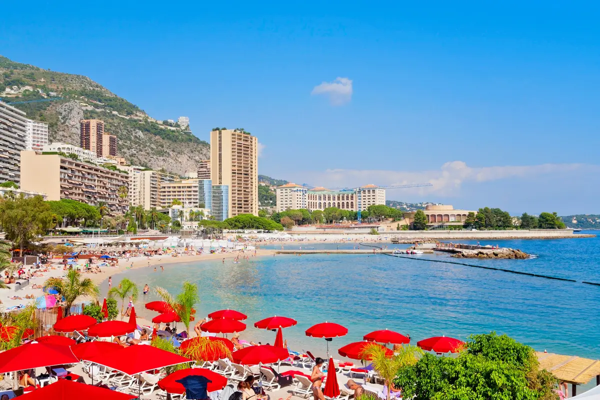 Larvotto beach, monaco in summer with red umbrellas
