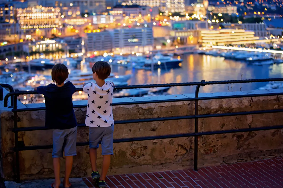 two kids looking at monaco yacht harbor